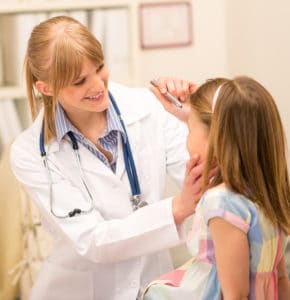 Pediatrician checking eye girl at medical office