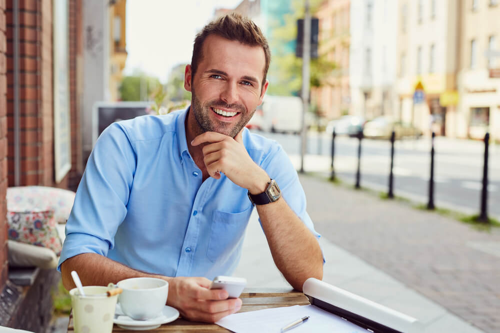 Smiling young professional man working outside of a restaurant