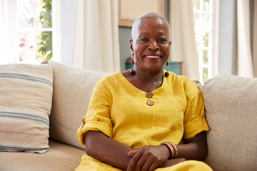 Smiling older woman on a sofa in a home setting