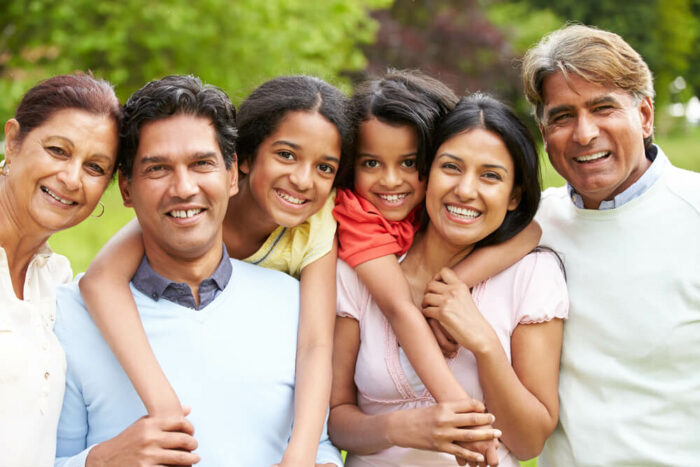 Smiling family with 2 young children and grandparents